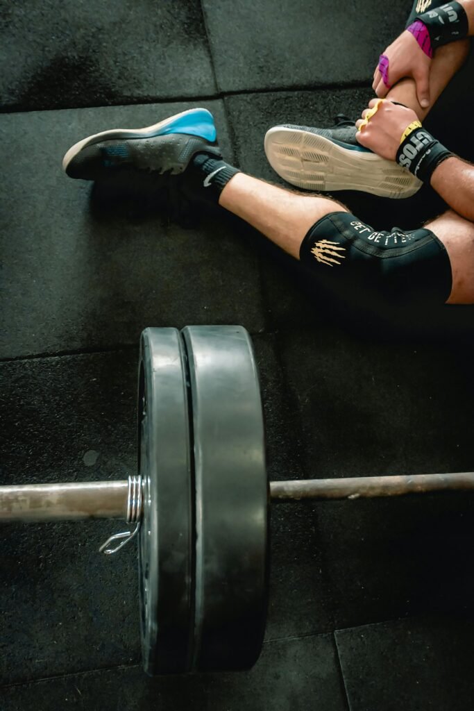 Close-up of an athlete in gym with weights focusing on fitness and strength.